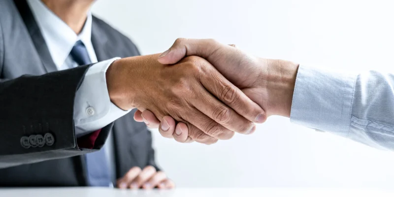 Avvocato dello Studio Legale Mancaniello & Partners Parma accoglie un nuovo cliente con una stretta di mano durante una consulenza legale