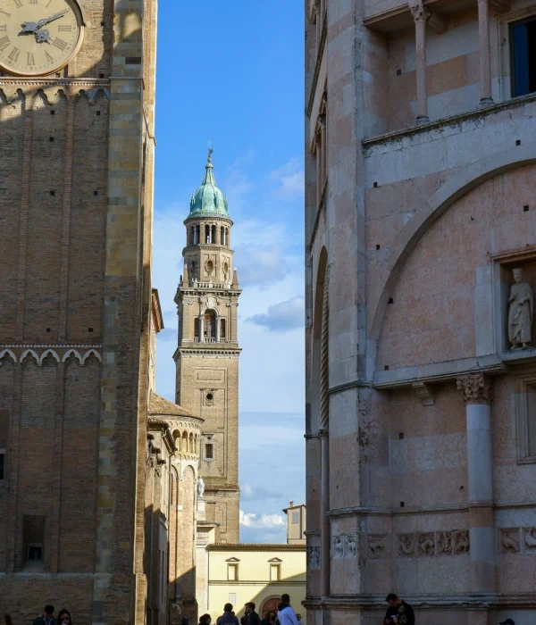 Vista ravvicinata della Piazza del Duomo di Parma con la torre campanaria della Cattedrale e la facciata del Battistero in marmo rosa, nel cuore della città dove ha sede lo studio legale Mancaniello & Partners
